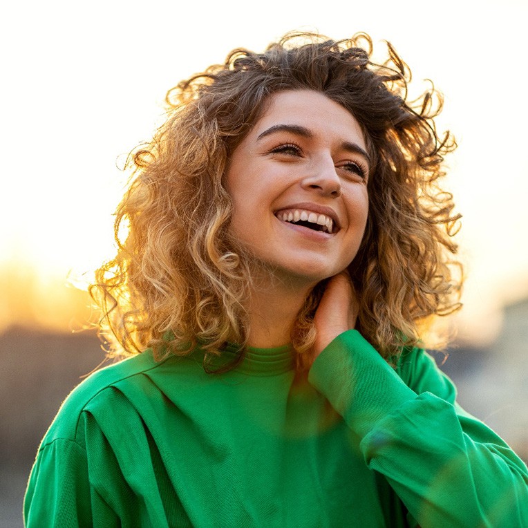 Smiling, happy woman standing outdoors