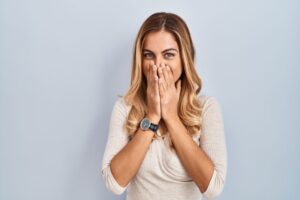 Smiling woman covering her mouth