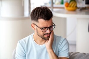 Grimacing man experiencing dental sensitivity 